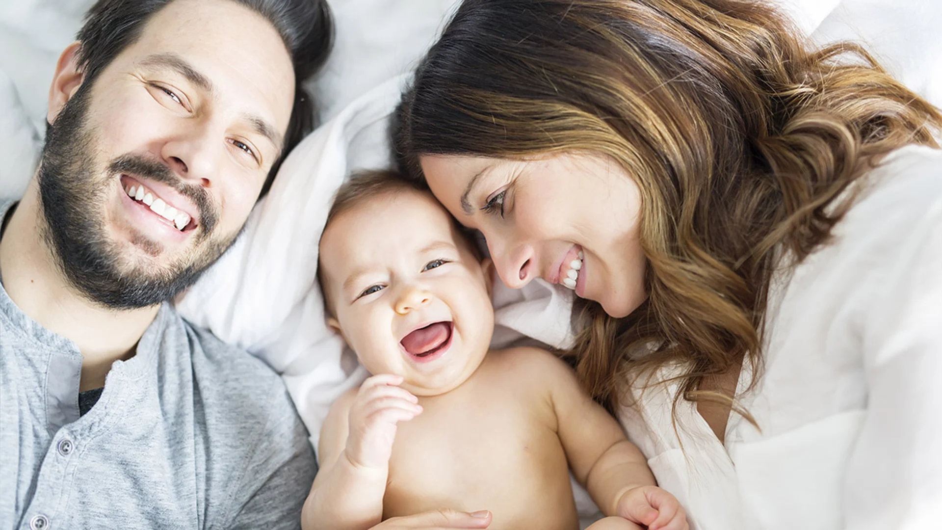 Happy new parents with their laughing baby